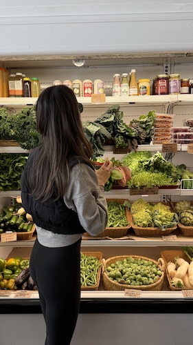 woman keeping to her grocery budget while shopping for produce