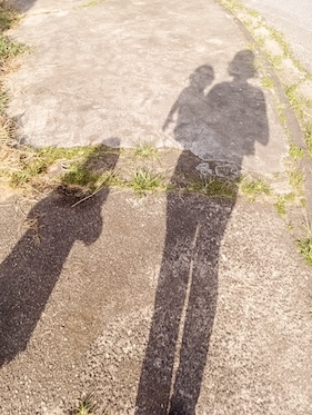 shadow of a mom with multiple kids showing on a sidewalk
