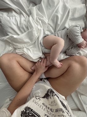 New mother comfortably resting with baby in cozy home setting