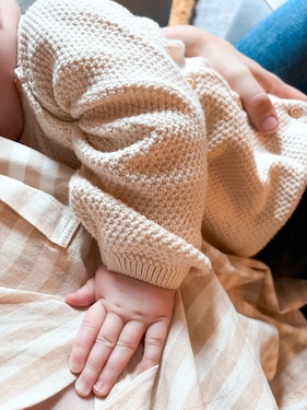new mother comfortably breastfeeding baby in cozy home setting